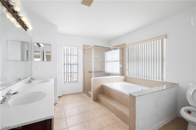 Full bathroom featuring double vanity, shower with