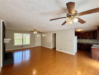Unfurnished living room featuring a textured ceili
