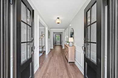 Entryway with crown molding and wood finished floors