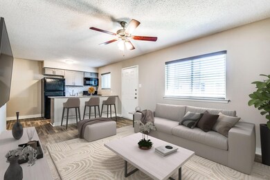Living area with baseboards, a textured ceiling, c