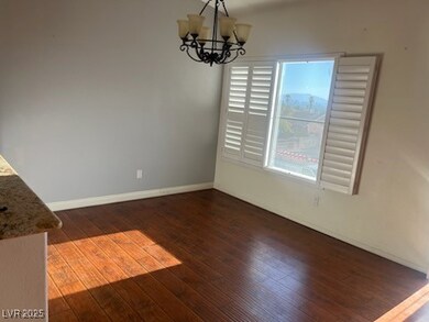 Unfurnished dining area featuring hardwood / wood-style floors and a chandelier