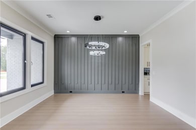 Unfurnished dining area with crown molding, light wood-style floors, a chandelier, and recessed lighting