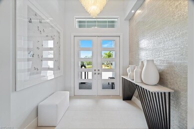 Foyer with a chandelier, french doors, and light t