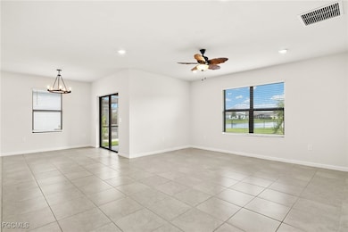 fFAMILY ROOMwith healthy amount of natural light, a chandelier, light tile patterned floors, ceiling fan, and recessed lighting