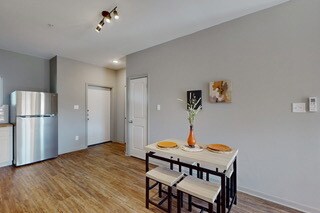 Dining room with wood finished floors and track li