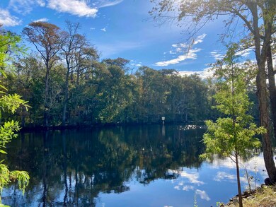 Property view of water with a wooded view