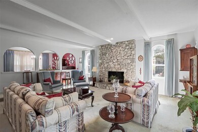 Living room with beamed ceiling, carpet, and a sto