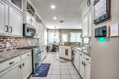 Stainless steel appliances and the brick backsplash make this kitchen so inviting