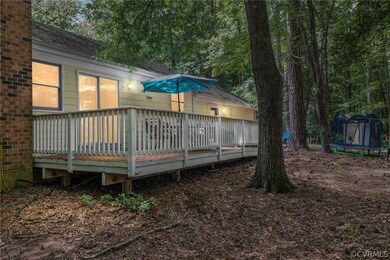 Back of property featuring a deck and a trampoline