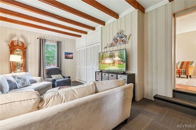 Living room with beam ceiling, a decorative wall,