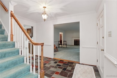 Foyer with stairway, ornamental molding, a chandel