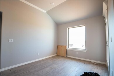 Empty room featuring vaulted ceiling and hardwood 