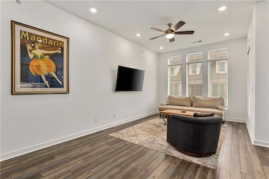 Living room featuring ceiling fan and dark hardwoo
