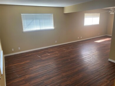 Empty room featuring baseboards, dark wood-style f