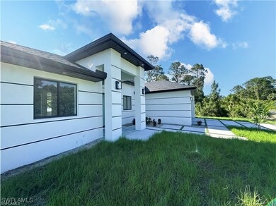 Rear view of property with a yard and a shingled r