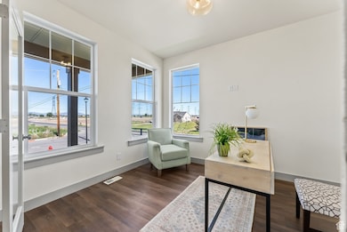 Living area featuring dark wood-style floors and baseboards
