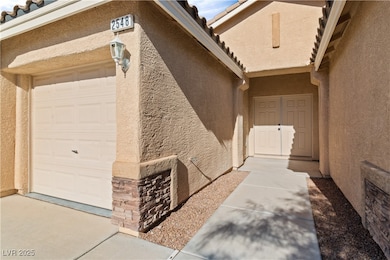 Property entrance with stucco siding, a tiled roof, and a garage