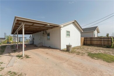 View of side of property featuring fence and a carport