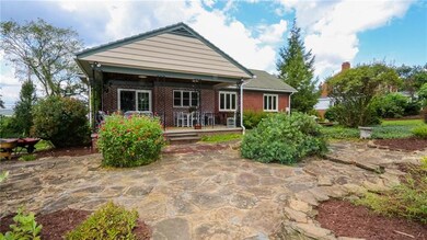 Exterior of home showing stone patio and covered b