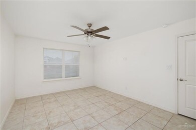 Spare room featuring light tile patterned floors and ceiling fan