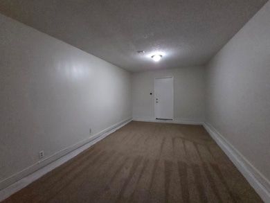Spare room with a textured ceiling and light carpet