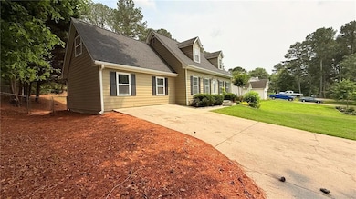 Cape cod-style house featuring concrete driveway and a shingled roof