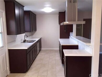 Quartz Countertops, Cappuccino Wood Cabinets, Stainless Steel Kitchen Hood Vent, Stainless Steel Dishwasher.