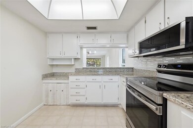 Kitchen featuring stainless steel appliances, white cabinets, and tasteful backsplash