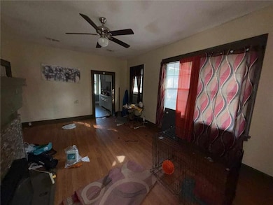 Unfurnished living room featuring wood finished floors and ceiling fan