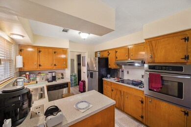 Kitchen area with wooden cabinets and ceramic tile