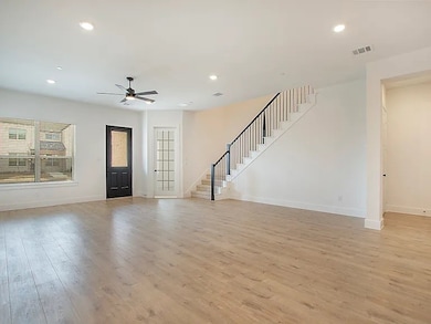 Spacious living area with recessed lighting and an inviting flow to the staircase and upper level.