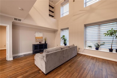 Living area with dark wood-style flooring, crown m