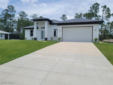 View of front facade featuring driveway, a front y