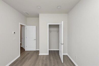Unfurnished bedroom featuring dark wood-style floors and a closet