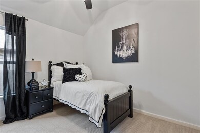 Bedroom with light carpet, lofted ceiling, baseboards, and ceiling fan