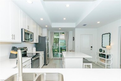 Kitchen featuring stainless steel appliances, a kitchen island, recessed lighting, white cabinetry, and a kitchen breakfast bar