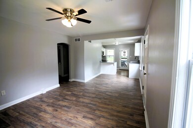 Unfurnished living room featuring sink, dark hardw