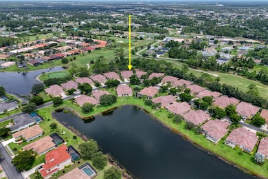 Aerial view of property's location featuring a nearby body of water, nearby suburban area, and a golf club