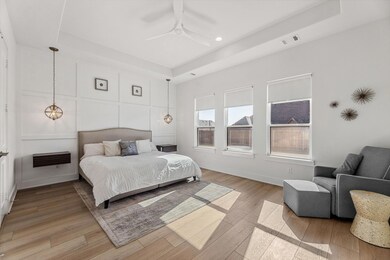 Bedroom featuring a tray ceiling, a decorative wal