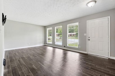 Unfurnished living room with dark wood finished fl