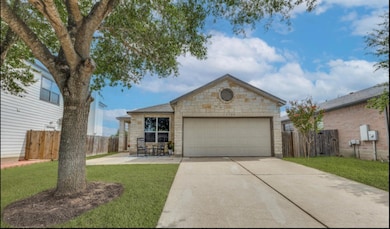 Single story home with stone siding, concrete driveway, and a patio