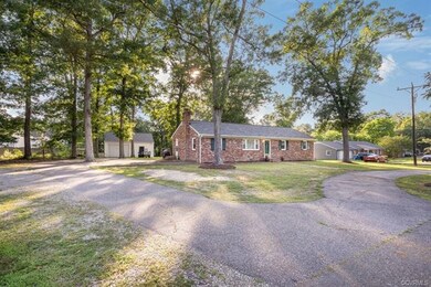 Side of home with detached garage and paved drive.