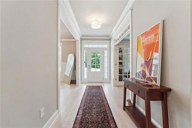 Entryway with ornamental molding and light hardwood flooring