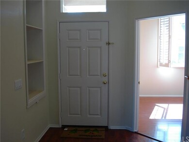 VIEW OF FRONT DOOR WITH WOOD FLOORED FOYER AND BUI