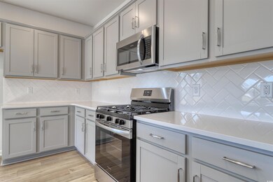 Kitchen with gray cabinets, decorative backsplash,