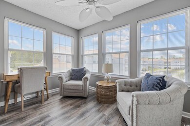 Sunroom / solarium featuring wood finished floors, baseboards, and a textured ceiling