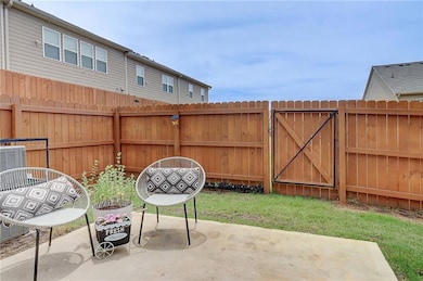 Fenced backyard featuring a patio area and a gate