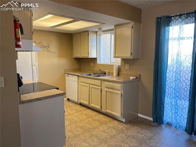 Kitchen featuring a sink, dishwasher, range, light countertops,
