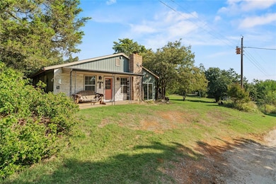 View of front of house featuring a porch, a front yard, a chimney, and board and batten siding