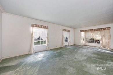 Unfurnished living room with carpet flooring and ornamental molding